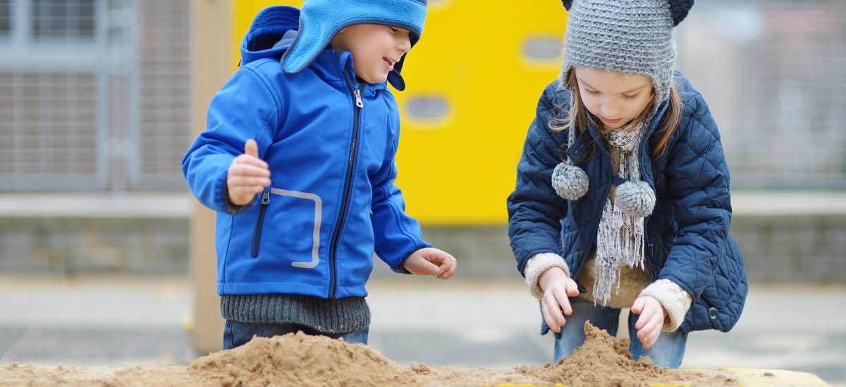 Två barn som gräver i en sandlåda