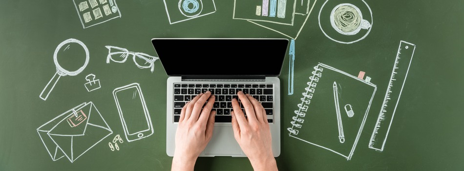 Bild uppifrån med bärbar dator och två händer som skriver på datorn på ett grönt underlag med illustrationer på